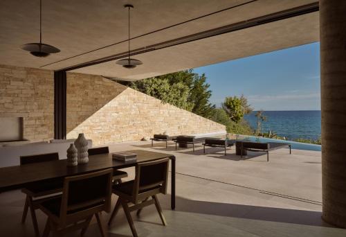 a dining room with a view of the ocean at Opsis villas, A waterfront & architectural retreat in Akrotiri