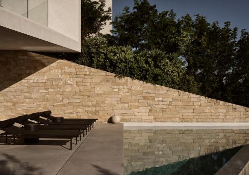 a group of benches sitting next to a brick wall at Opsis villas, A waterfront & architectural retreat in Akrotiri