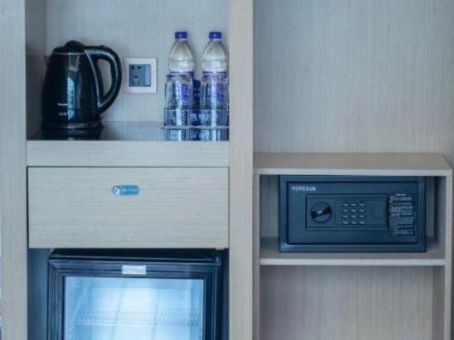 a cabinet with bottles of water and a microwave at Beluga Sanya Discovery Ocean World in Shangsimacun