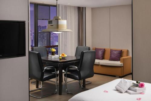 a room with a table and chairs and a couch at Lavande Hotels Liuyang Economic and Technology Development Zone in Liuyang