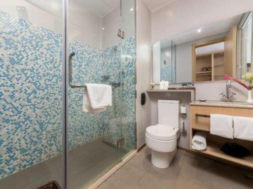 a bathroom with a toilet and a shower and a sink at Beluga Sanya Discovery Ocean World in Shangsimacun