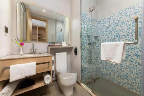 a bathroom with a toilet and a glass shower at Beluga Sanya Discovery Ocean World in Shangsimacun
