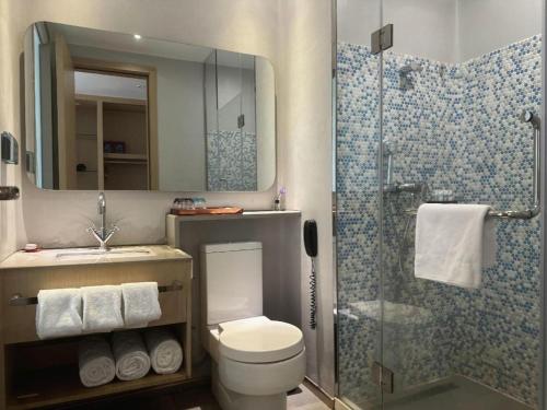 a bathroom with a toilet and a shower at Beluga Sanya Discovery Ocean World in Shangsimacun