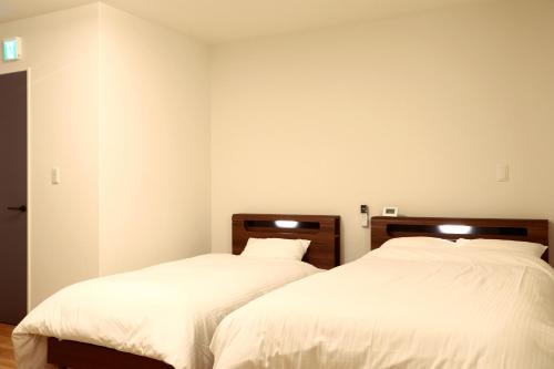 two beds sitting next to each other in a bedroom at ホテル森のしずく in Shimoda