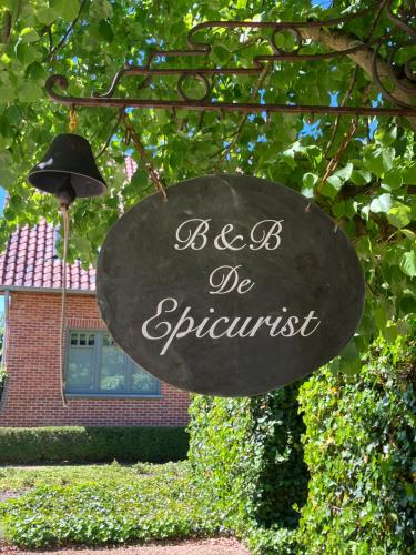 a sign that says be spontaneous in front of a house at De Epicurist in Hasselt