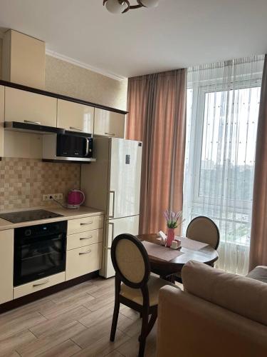 a kitchen with a table and chairs and a kitchen with a table and a couch at Apart Assistant on Smart Plaza in Kyiv