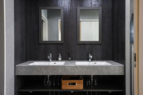 a bathroom with two sinks and two mirrors at マーレブル仙崎 in Nagato