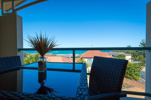 a view from a balcony of a beach with a view of the ocean at Beach Haven Executive Apartments in Coffs Harbour
