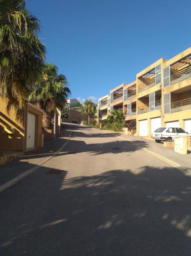 une rue vide avec des palmiers et un bâtiment dans l'établissement T2 2/6 p Clim vue mer piscine parking privé tout à pied, à Collioure