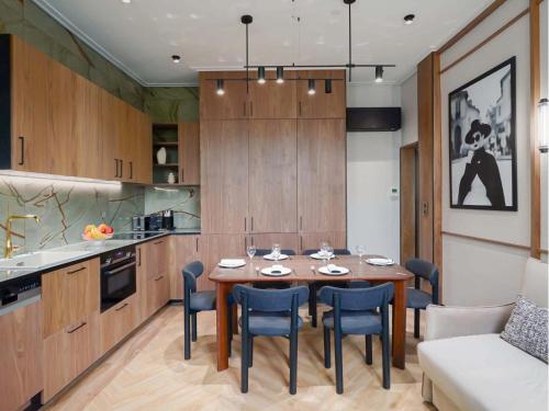 une cuisine avec une table et des chaises dans une pièce dans l'établissement Merveil - Signature Suite - Champs Elysees - Dulud I, à Neuilly-sur-Seine