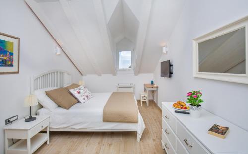 ドゥブロヴニクにあるPorta Apartments by Irundoの白い部屋(ベッド1台、テーブル付)