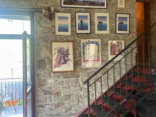 a stone wall with pictures on a staircase in a house at La casa di Ele in Apricale