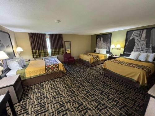 a hotel room with two beds and a television at Super 8 by Wyndham McLean/Bloomington SW in McLean
