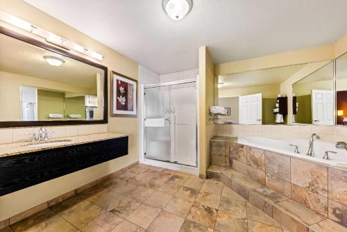 カルガリーにあるWingate by Wyndham Calgary Southのバスルーム(シンク2台、バスタブ、シャワー付)