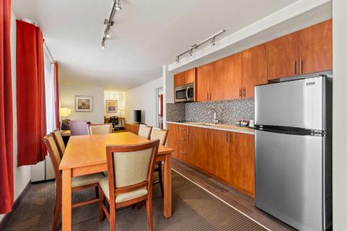 a kitchen and dining room with a table and a refrigerator at Wingate by Wyndham Calgary South in Calgary