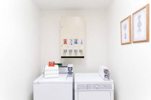 a white laundry room with a washer and dryer at Super 8 by Wyndham Montpelier in Montpelier