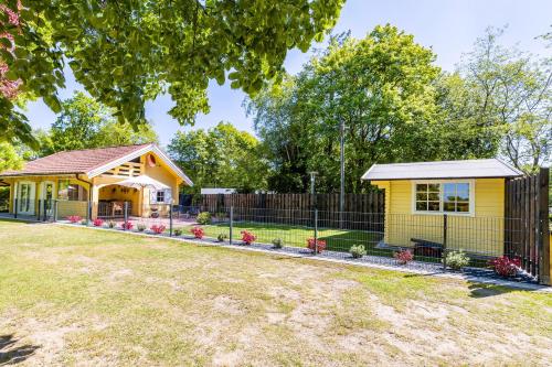 a yellow house with a fence in a yard at Haus Miriam in Walchum