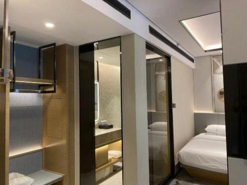 a small room with a bed and a bathroom at Jinan Silver Plaza Quancheng Hotel in Jinan
