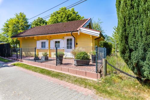 a small yellow house with a fence in front of it at Haus Miriam in Walchum
