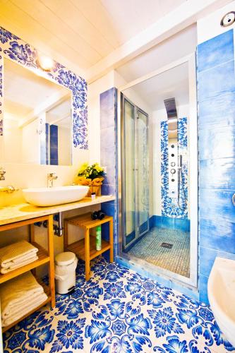 a blue and white bathroom with a shower and sink at Alfieri Rooms - Amalfi coast in Atrani