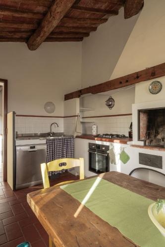 a kitchen with a wooden table and a kitchen with appliances at Agriturismo La Ca'Solare in Palaia