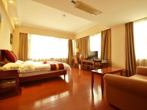 a hotel room with a bed and a living room at GreenTree Inn Shanghai Jingan Railway Station Xinzha Road Business Hotel in Shanghai