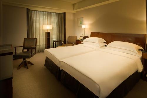 a large white bed in a hotel room at Les Suites Taipei - Da An in Taipei
