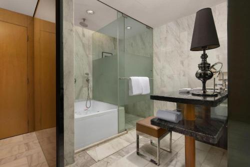 a bathroom with a shower and a tub and a sink at Changsha Huatian Hotel in Changsha