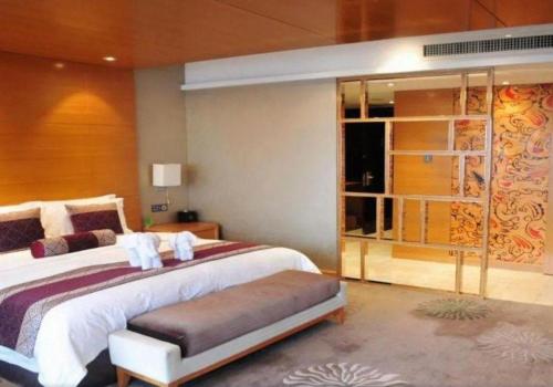 a bedroom with a large bed with towels on it at Changsha Huatian Hotel in Changsha