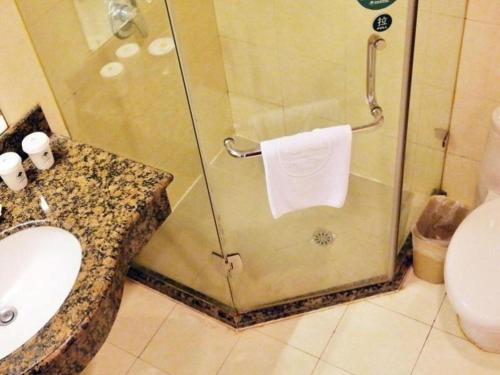 a bathroom with a shower with a sink and a toilet at GreenTree Inn Shanghai Jingan Railway Station Xinzha Road Business Hotel in Shanghai