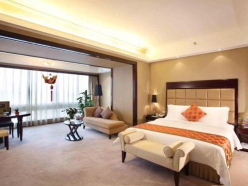 a large bedroom with a large bed and a desk at Changsha Huatian Hotel in Changsha