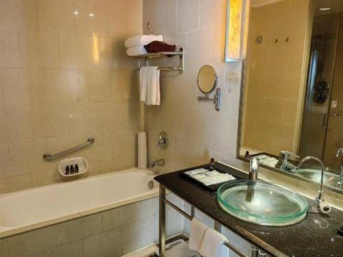 a bathroom with a sink and a bath tub and a bath tub at Changsha Huatian Hotel in Changsha