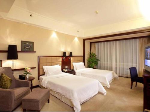 a hotel room with two beds and a television at Changsha Huatian Hotel in Changsha