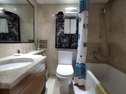 a bathroom with a toilet and a sink and a tub at Changsha Huatian Hotel in Changsha