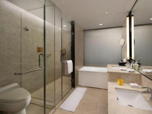a bathroom with a shower and a toilet and a sink at Changsha Huatian Hotel in Changsha