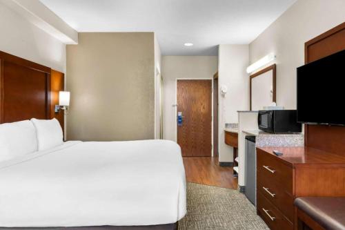 a hotel room with a large bed and a kitchen at Comfort Inn & Suites in Riverton