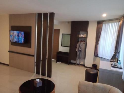 a living room with a refrigerator and a table at Alexander Hotel Tegal in Tegal