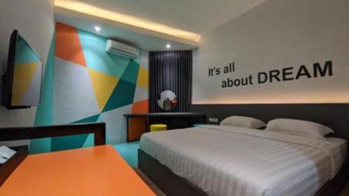 a bedroom with a bed and a colorful wall at Alexander Hotel Tegal in Tegal