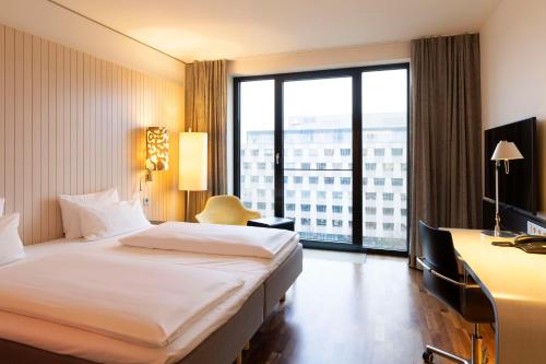 a hotel room with a bed and a large window at Scandic Berlin Potsdamer Platz in Berlin