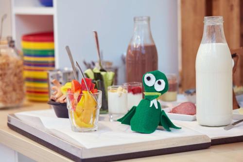 a toy frog sitting on a cutting board with milk at Scandic Berlin Potsdamer Platz in Berlin