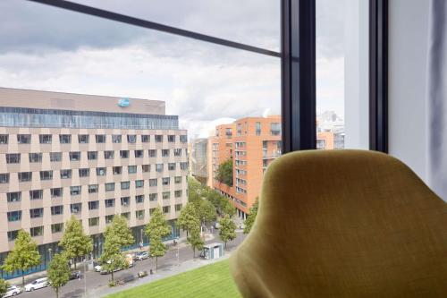 a yellow chair sitting in front of a window at Scandic Berlin Potsdamer Platz in Berlin