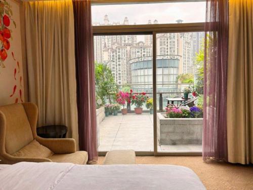 a hotel room with a bed and a view of a balcony at Jiaxin Conifer Hotel Shunde in Shunde