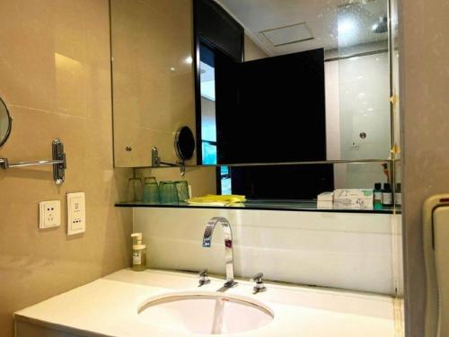 a bathroom with a sink and a mirror at Jiaxin Conifer Hotel Shunde in Shunde