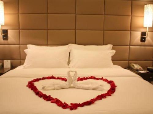 a heart made out of flowers on a bed at Jiaxin Conifer Hotel Shunde in Shunde
