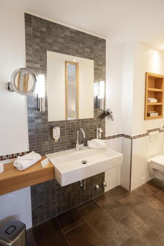 a bathroom with a sink and a toilet at Romantikhotel Platte in Attendorn