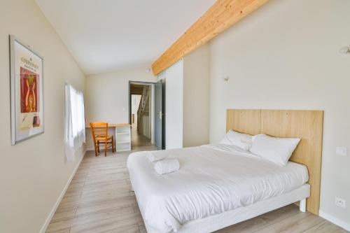 a bedroom with a white bed and a table at La Jarnacaise #12pers #6 chambres in Jarnac