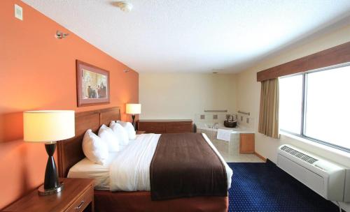 a hotel room with a bed and a window at AmericInn by Wyndham Cedar Rapids Airport in Cedar Rapids