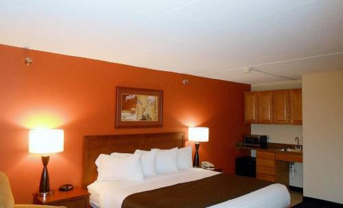 a hotel room with a bed and two lamps at AmericInn by Wyndham Cedar Rapids Airport in Cedar Rapids