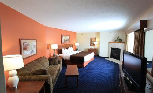 a hotel room with a bed and a couch at AmericInn by Wyndham Cedar Rapids Airport in Cedar Rapids