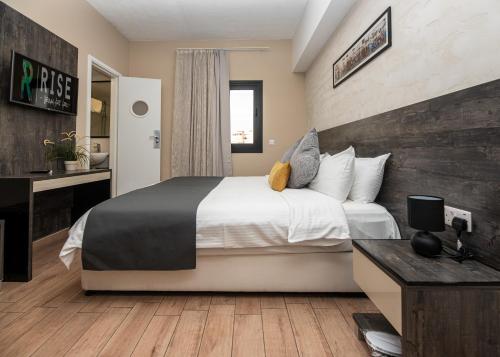 a bedroom with a large bed and a desk at Rise Urban Art Hotel in Larnaka